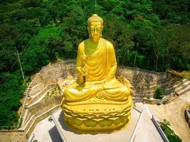 Ariel view Golden Buddha statue's hand holding lotus at Chon Khong Monastery which attracts tourists to visit spiritually on weekends in Vung Tau, Vietnam. Travel concept. photo