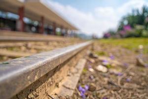 Railway station against beautiful sky at Da Lat Station. Industrial landscape with railroad, colorful blue sky, sun, trees and green grass. Railway junction. Heavy industry. photo