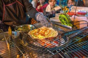 Close up Grilled girdle cake Banh Trang Nuong , a famous Vietnamese street stall eatery, a popular Vietnamese food in Da lat at night photo