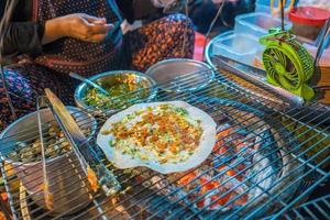 Close up Grilled girdle cake Banh Trang Nuong , a famous Vietnamese street stall eatery, a popular Vietnamese food in Da lat at night photo