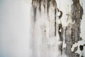 Rough texture on gray wall rough form due to peeling paint layer due to rain. photo