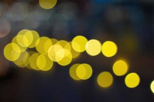 el bokeh de la ciudad nocturna brilla con un fondo claro vacío. banner luz de las velas brilla oro amarillo brillo abstracto. celebración de fondo de diseño foto