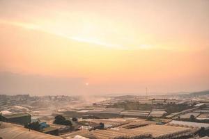 Amazing sunset landscape in agricultural greenhouse valley in Da Lat City. The light from the greenhouse to grow flowers in Da Lat. Travel and landscape concept photo