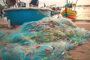 Sea nets - fishing equipment or tackle as texture backdrop with natural sunlight and shadow. Blue textured background of fishing nets close-up, marine design for craft of fishermen. photo