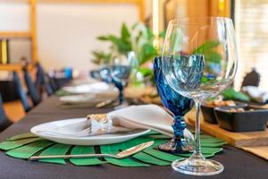 Luxury Lunch or Dinner set on the long table pattern with a black cover table with flower decoration. photo