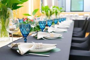 Luxury Lunch or Dinner set on the long table pattern with a black cover table with flower decoration. photo