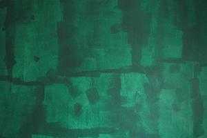 pared pintada sin terminar de color verde, reparaciones en el hogar. textura que muestra rastros de rodillos de pintura. foto