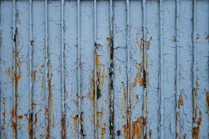 Old rusty metal fence, covered in paint and debris, frontal photo. Soviet era gray metal fence texture. photo