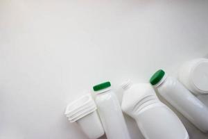 White plastic bottles on white background with place for your design. Top view photo