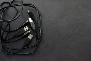Close up USB and mini USB cables on black background with place for your design photo
