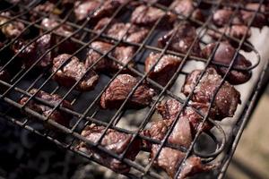 meat is fried on the grill over the coals photo