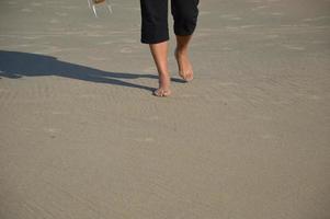 Woman feet in the sand at the beach photo