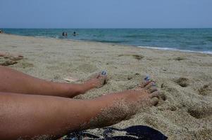 Woman feet in the sand at the beach photo