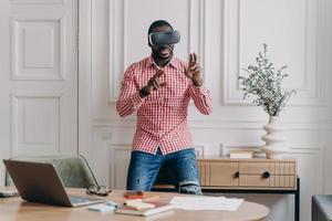 Young programmer or software developer African American man in VR headset glasses testing 3D games photo