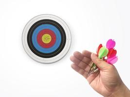 Human hand is throwing the darts target to the darts board. a man's hand throws a dart at the target photo