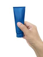 Hand holding Cosmetic plastic tube isolated on white background photo