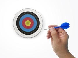 Human hand is throwing the darts target to the darts board. a man's hand throws a dart at the target photo