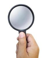 Hand holding a magnifying glass isolated on a white background photo