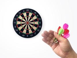 Human hand is throwing the darts target to the darts board. a man's hand throws a dart at the target photo