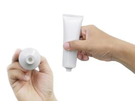 Hand holding Cosmetic plastic tube isolated on white background photo