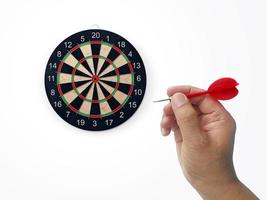 Human hand is throwing the darts target to the darts board. a man's hand throws a dart at the target photo