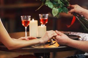 sentado junto a la mesa. pareja romántica cenar en el restaurante foto