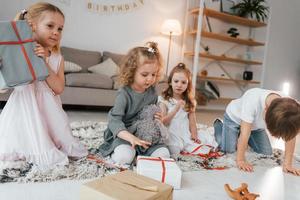 con cajas de regalo. cumpleaños de celebración. grupo de niños está juntos en casa durante el día foto