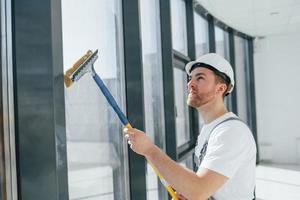 limpieza de ventanas sucias. reparador está trabajando en el interior de la habitación moderna foto