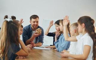 With puzzle. Group of children students in class at school with teacher photo