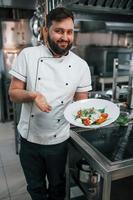 Finished salad. Ready to eat. Professional chef preparing food in the kitchen photo