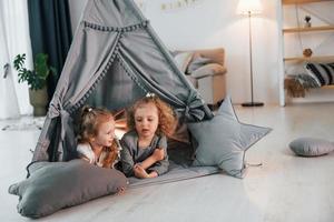 In the tent. Two children is together at home at daytime photo