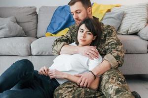 Defending Ukraine. Soldier in uniform is at home with his wife photo