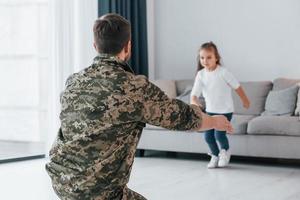 Missed you. Soldier in uniform is at home with his little daughter photo