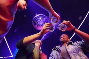 View from below. Group of friends having fun in the night club together photo