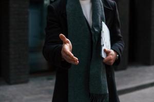 Close up view of man in formal clothes that gives hand to shake. Conception of agreement photo