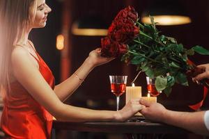 Sitting by the table. Romantic couple have dinner in the restaurant photo