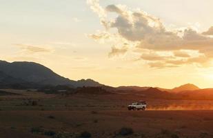 montando al aire libre. coche en los desiertos de áfrica, namibia foto