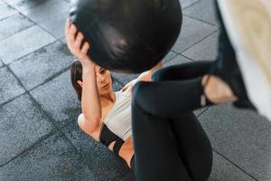 With fitness ball. Woman in sportive clothes with slim body type is in the gym photo