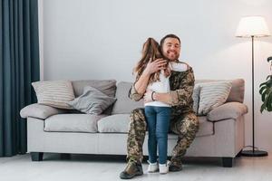 Missed you. Soldier in uniform is at home with his little daughter photo