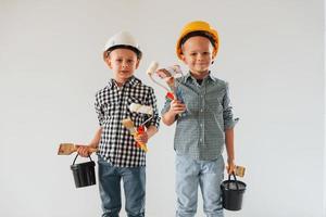 Friends together indoors. Two boys painting walls in the domestic room photo