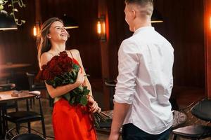 rosas hermosas. pareja romántica cenar en el restaurante foto