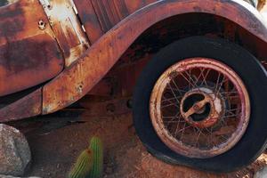 Close up view of old rusty car in the desert photo