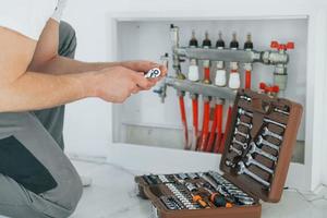 Close up view. Repairman is working indoors in the modern room photo