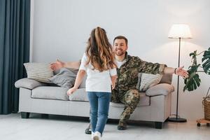 Missed you. Soldier in uniform is at home with his little daughter photo