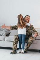 Missed you. Soldier in uniform is at home with his little daughter photo