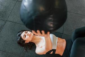 With fitness ball. Woman in sportive clothes with slim body type is in the gym photo