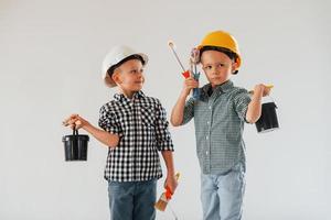 Friends together indoors. Two boys painting walls in the domestic room photo