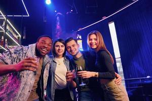 Party time. Group of friends having fun in the night club together photo