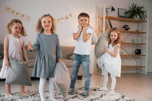 divirtiéndose en la fiesta de cumpleaños. grupo de niños está juntos en casa durante el día foto