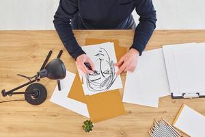 Top view of painter that working on the sketch of a man photo